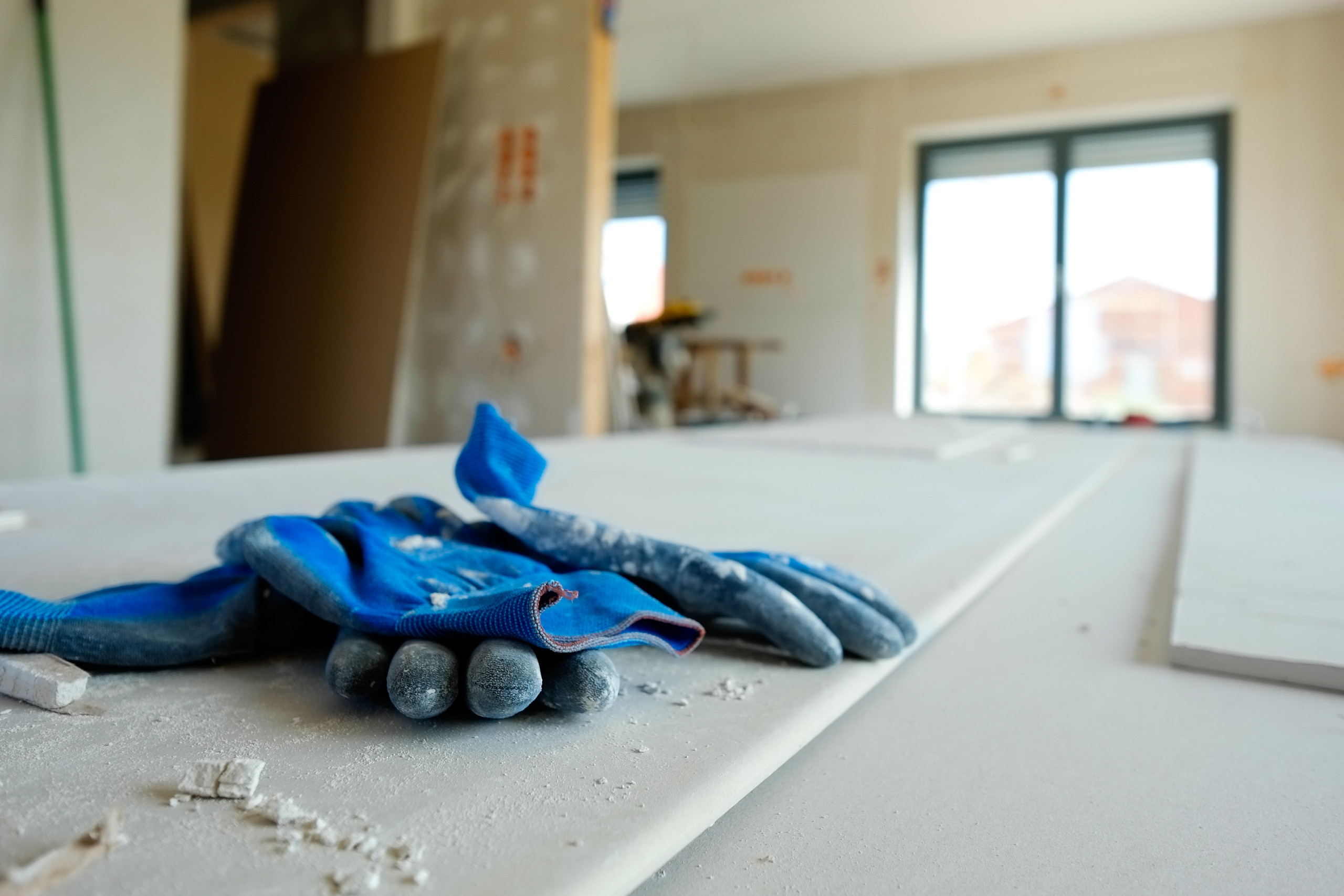 Handschuhe liegen auf Trockenbau-Platten